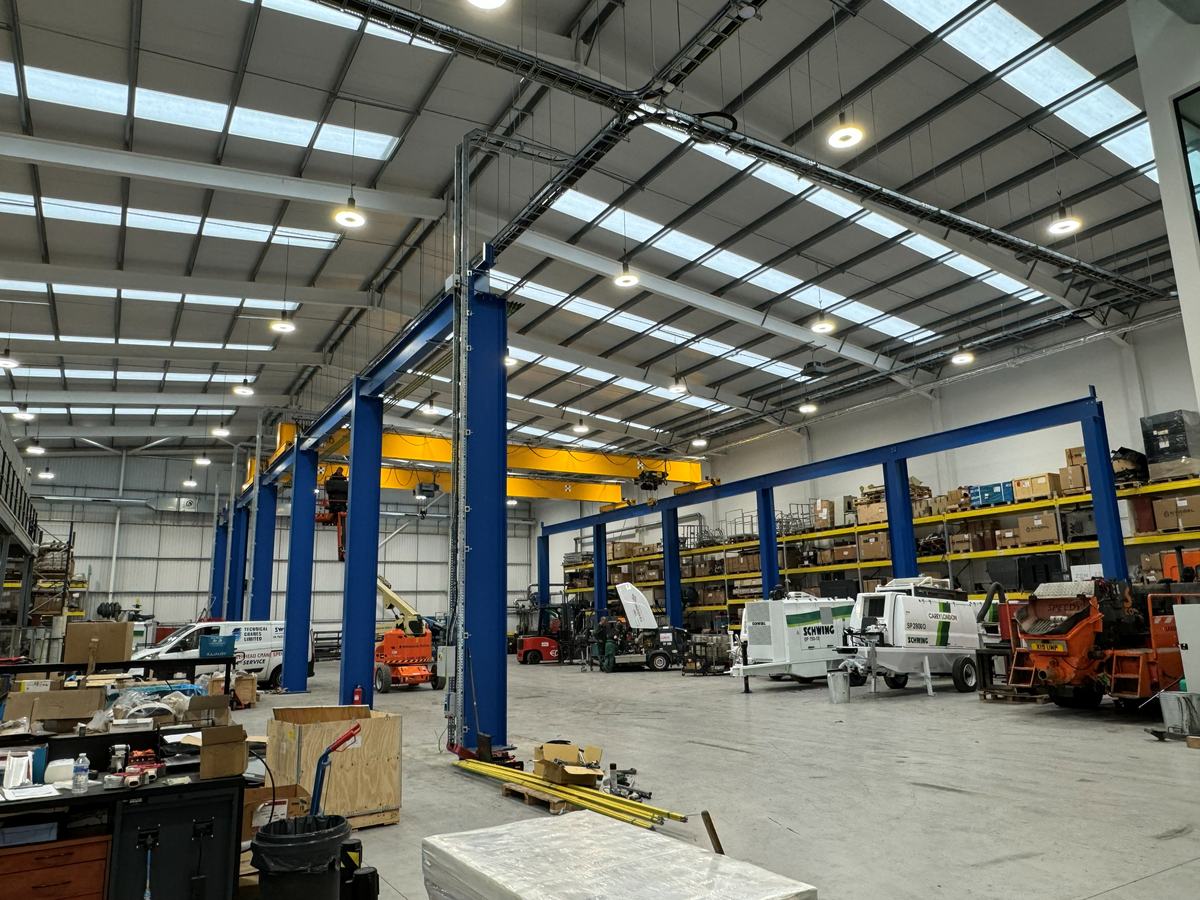 High-bay lighting and power distribution installed through an industrial workshop with an overhead gantry crane — photograph 20 of 25