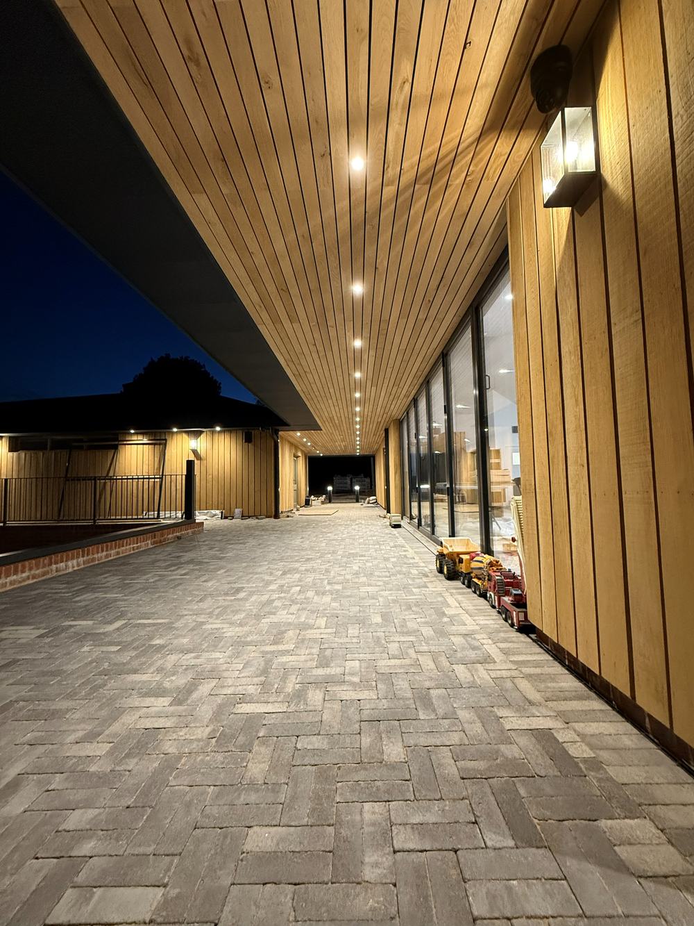 The colonnade at Dragonfly Farm Shop & Café at dusk, soffit and wall lighting running the length of it — photograph 25 of 25